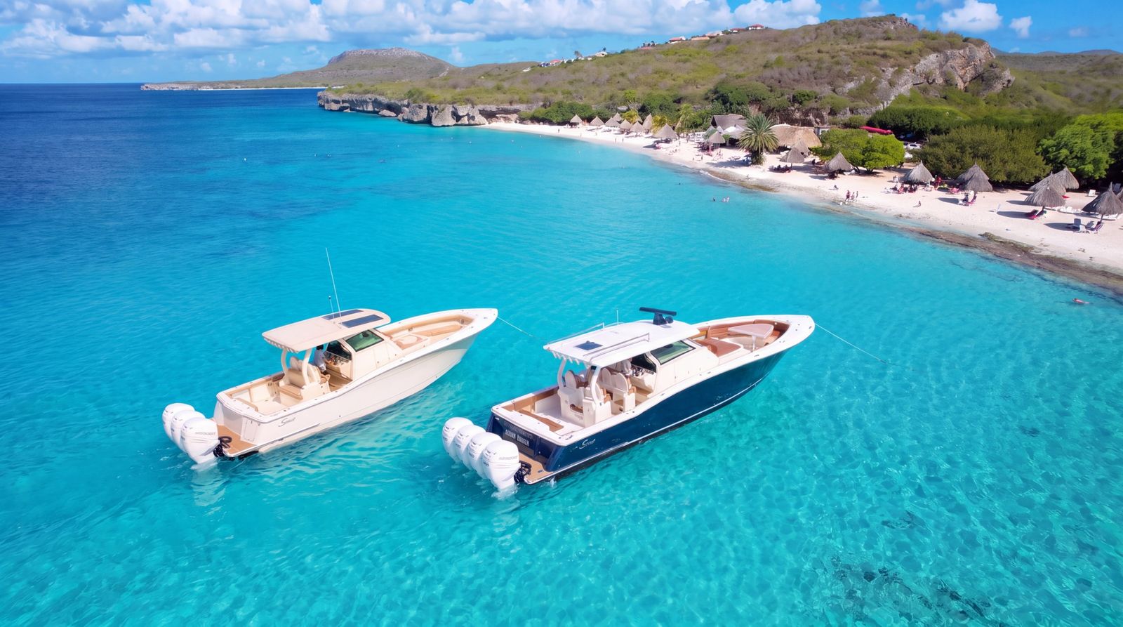 The Scout 355 and the Scout 420 at anchor side by side off a white beach in Curaçao